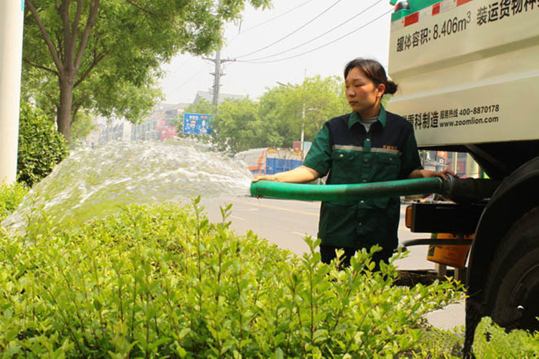 绿化公司工人对植物举行浇灌